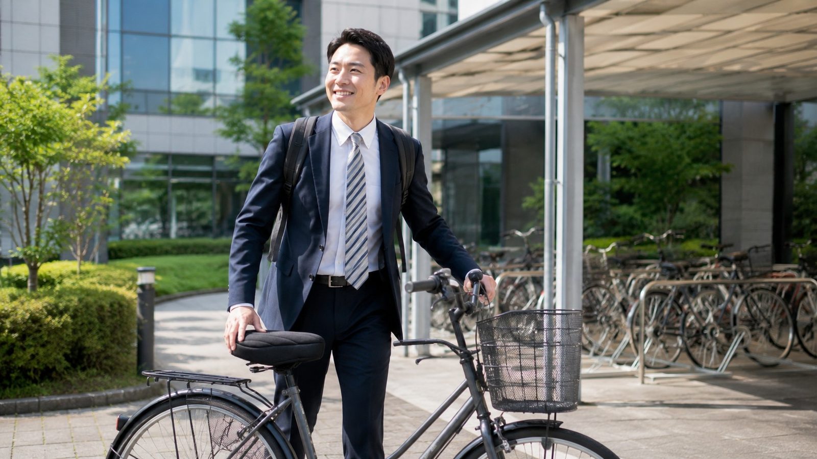 自転車で職場に到着し快適そうに降りるスーツ姿のビジネスマン